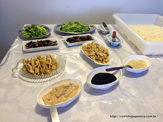 Mesa com arroz de sushi e ingredientes do recheio para o temaki