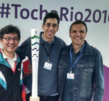 Eu e meus amigos e sócios, em frente à tocha olímpica na sede do COI, no Rio de Janeiro