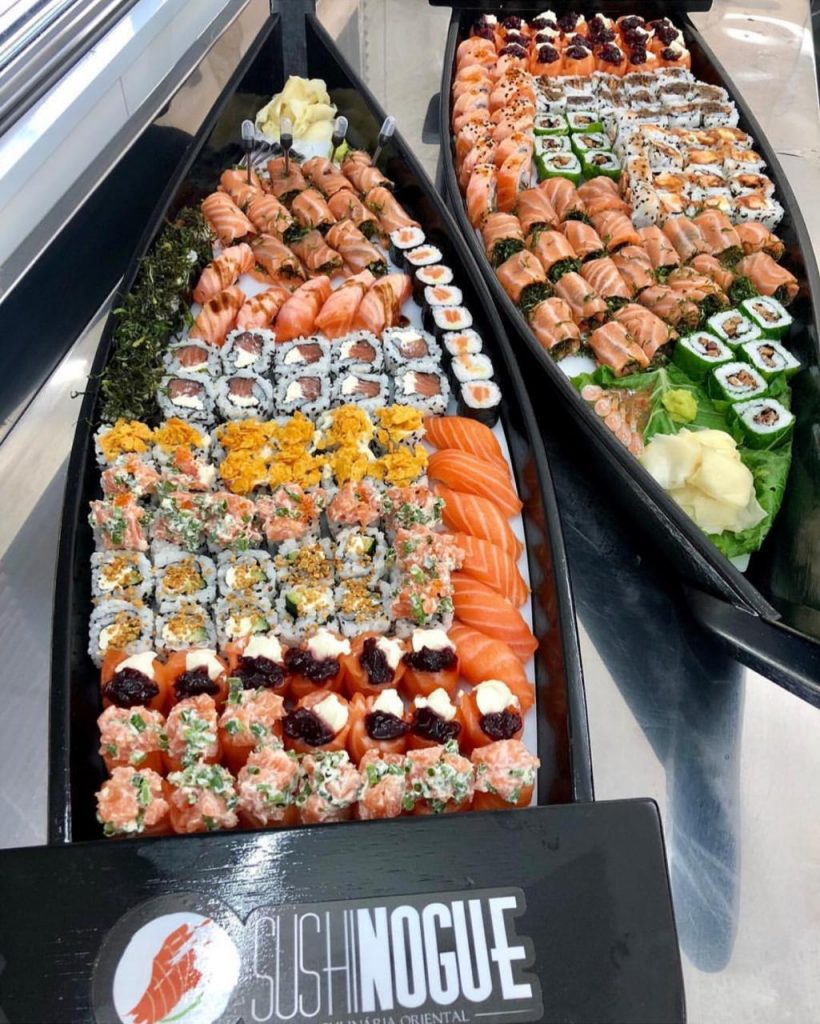Foto de barcas com peças variadas de sushi para delivery